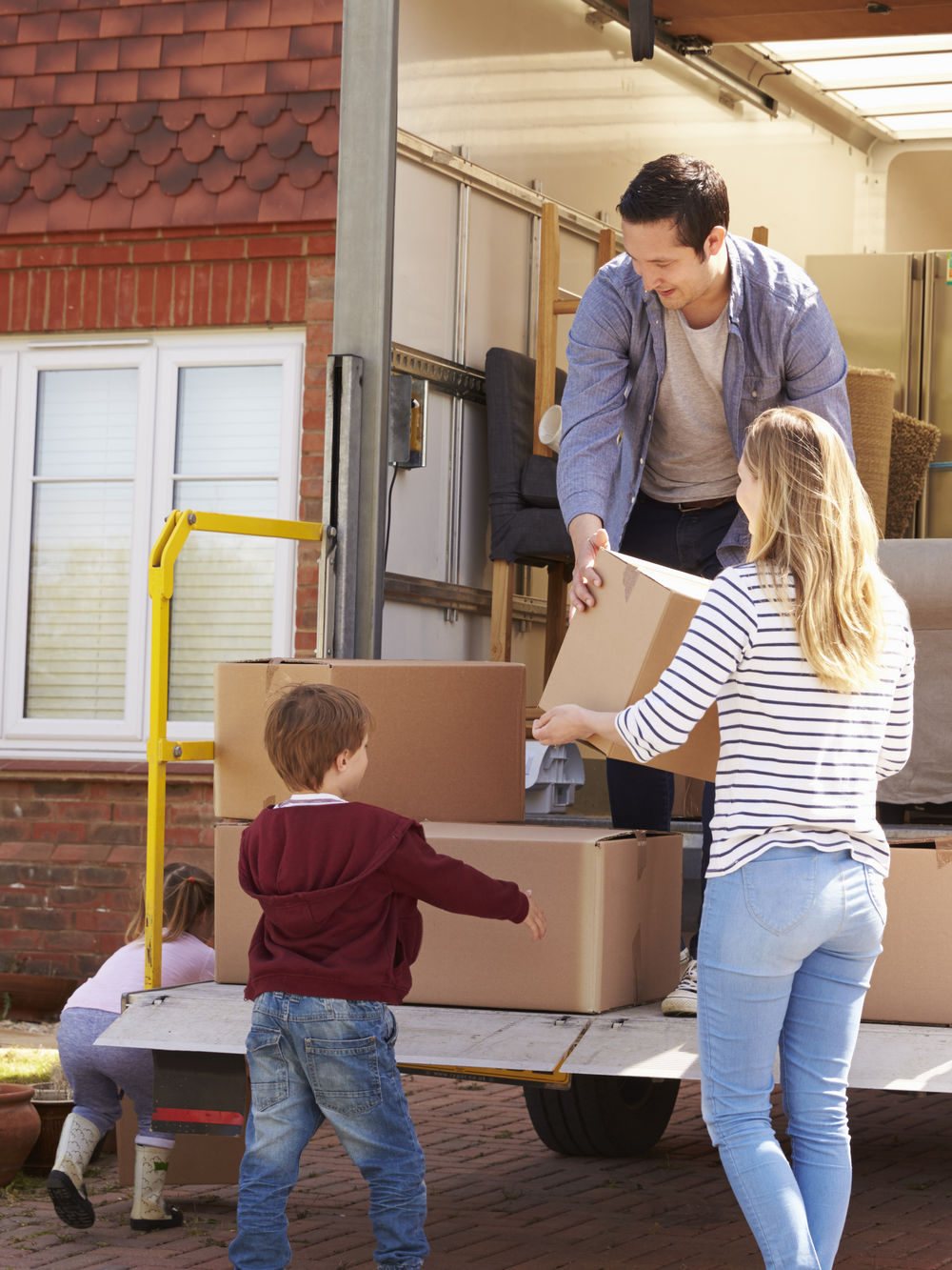 Family,Unpacking,Moving,In,Boxes,From,Removal,Truck