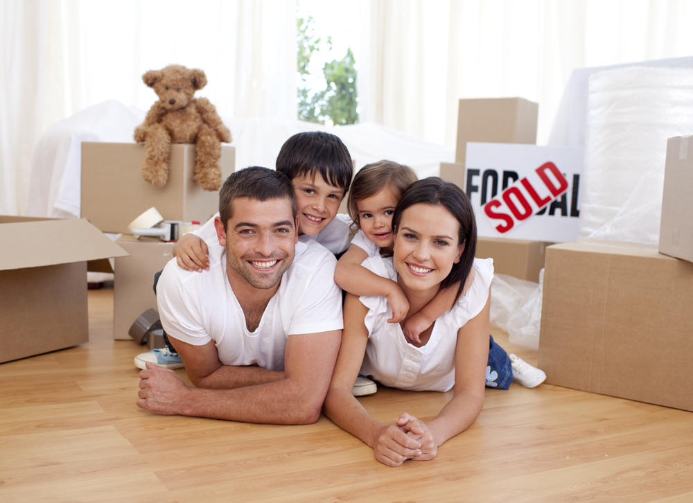 Happy family lying on floor after buying new house